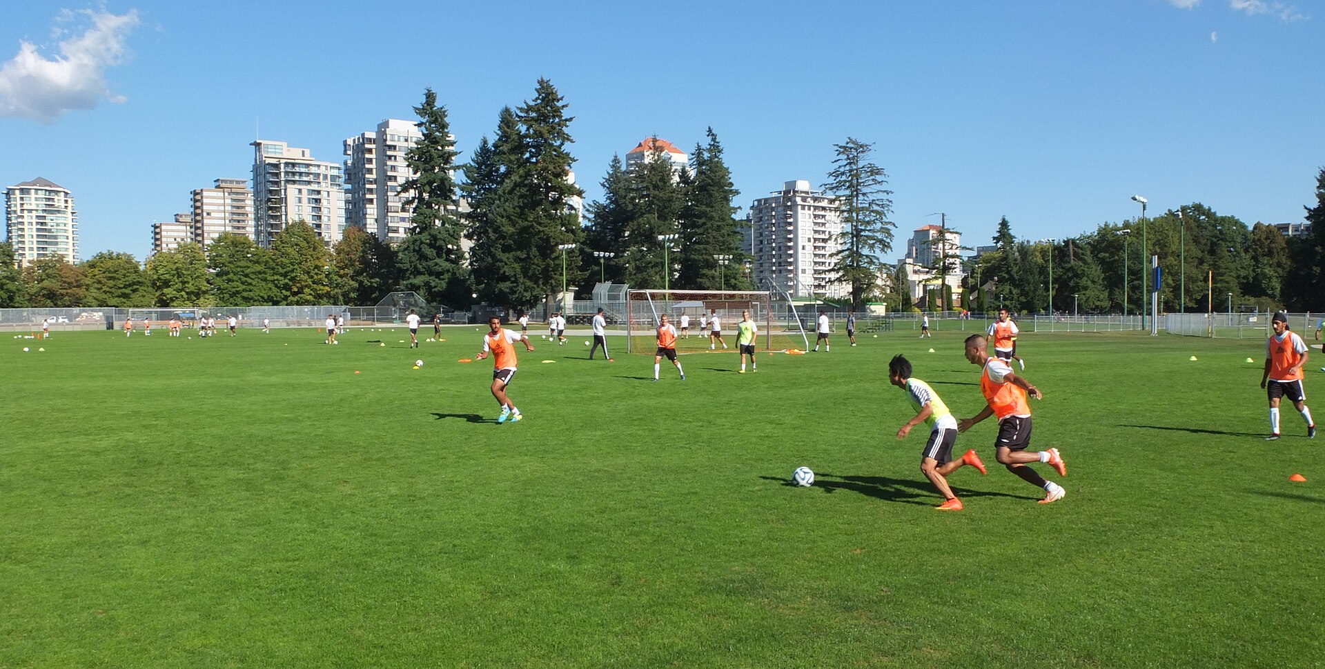 Soccer players practicing on a public field in New Westminster, British Columbia